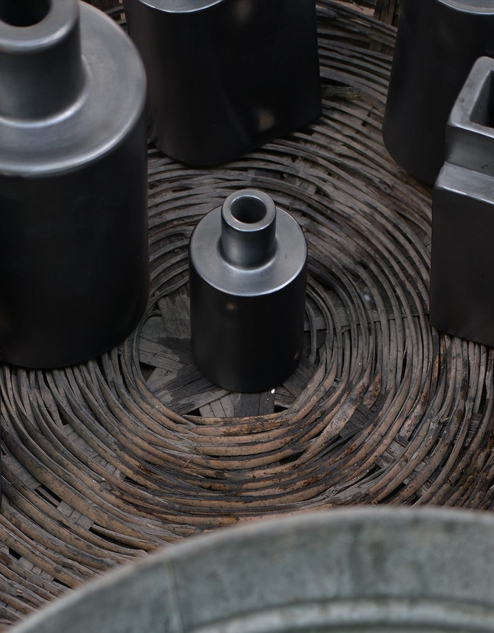 Black ceramic pots on a woven surface