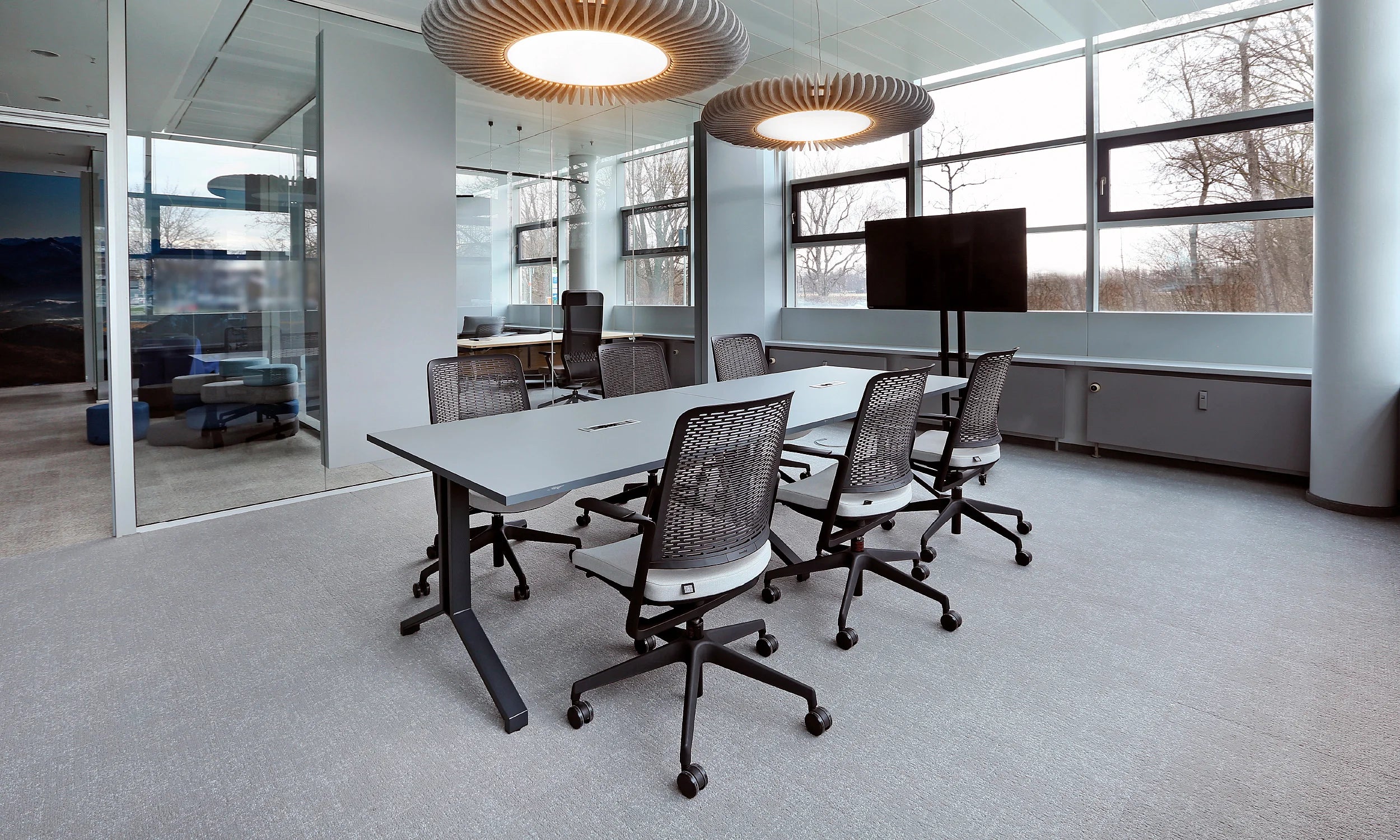 Flexxica Sol acoustic pendants above a meeting table in the Kusch+Co Nowy Styl showroom, Munich